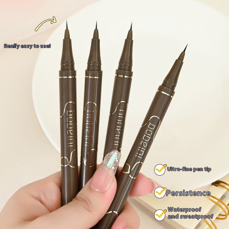 Four brown eyeliner pens held by a hand with a beige background
